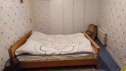 um pequeno quarto com uma cama com um cobertor de flores em Olympique Paris 2024 em Maisons-Alfort
