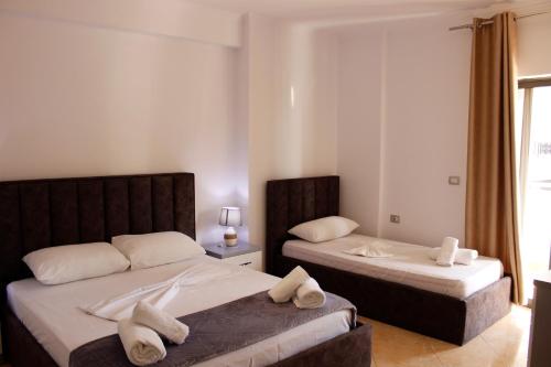 um quarto com 2 camas e toalhas em ElMar Apartments em Saranda