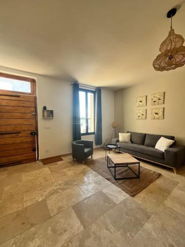 a living room with a couch and a table at Le Platane Maison climatisée avec piscine in Monteux