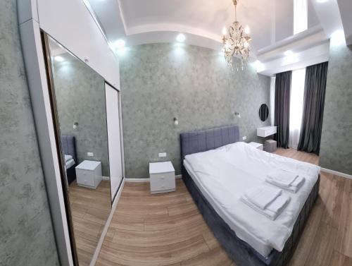 a bedroom with a white bed and a mirror at daily rent Taha Plaza in Tbilisi City
