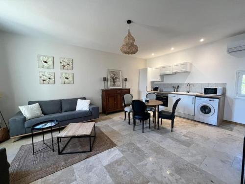 a living room with a couch and a table and chairs at Le Platane Maison climatisée avec piscine in Monteux