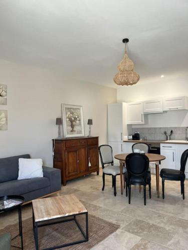 a living room with a couch and a table and chairs at Le Platane Maison climatisée avec piscine in Monteux