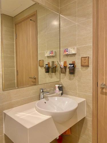 y baño con lavabo blanco y espejo. en Quân's homestay en Ho Chi Minh