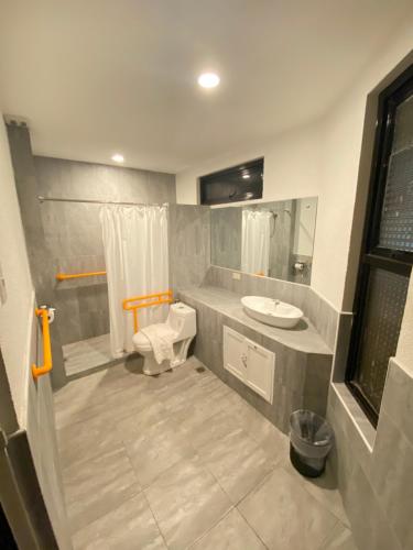 a bathroom with a toilet and a sink at Rudolfo Suites in Roxas City