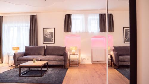 多瑙河畔克雷姆斯的住宿－Smile Apartments im Stadtzentrum，客厅配有沙发和桌子