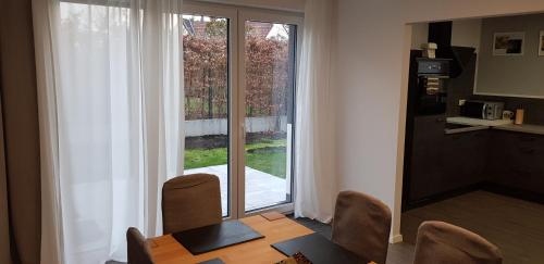 a dining room with a table and chairs and a window at City und Garten in Erftstadt