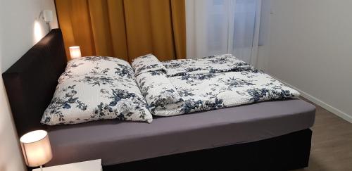 Una cama con cuatro almohadas encima. en City und Garten, en Erftstadt