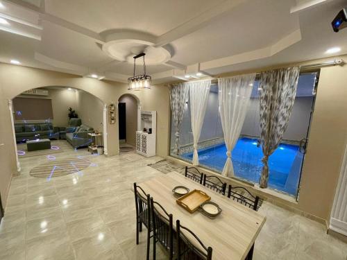 uma sala de estar com uma mesa e uma piscina em استراحة شادن em Iambo