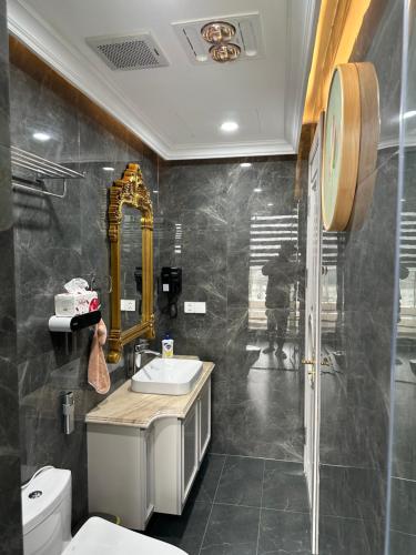 een badkamer met een wastafel en een spiegel bij penthouse fully furnished in Hai Phong