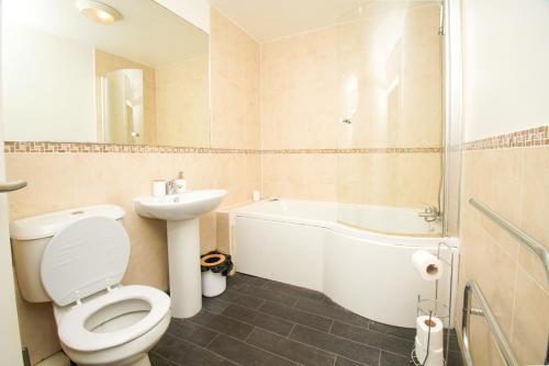 a bathroom with a toilet and a tub and a sink at 3 bed apartment, centre of Rochdale in Rochdale