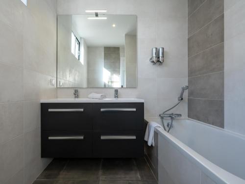 une salle de bain avec un lavabo, une baignoire et un miroir dans l'établissement Le Spacieux , 7 personnes, 6 lits, PARKING, proche LYON PARTDIEU, à Villeurbanne