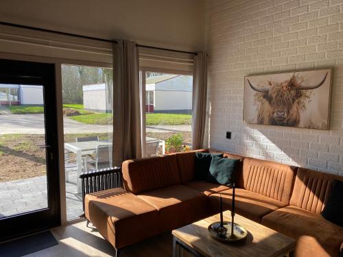 a living room with a couch and a bull painting on the wall at Huuske14 in Simpelveld