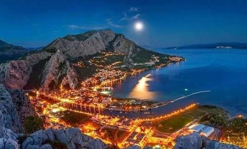 an aerial view of a town on a mountain at night at Beachfront apartment Plaza in Omiš