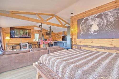 een woonkamer met een bank en een beer aan de muur bij romantique cabane perchée avec spa vue panoramique Le Mas des Faraches in Solliès-Toucas