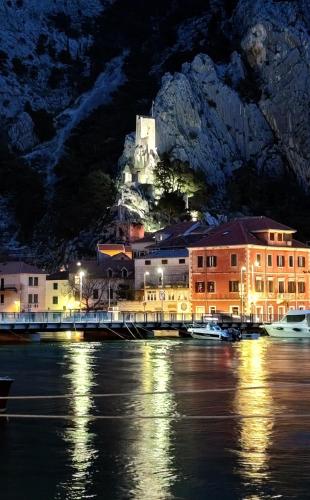 a town with a castle on top of a mountain at night at Beachfront apartment Plaza in Omiš