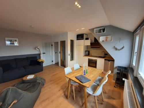 uma sala de estar com uma mesa e cadeiras e um sofá em Moewennest-by-DeJu-Norderney em Norderney