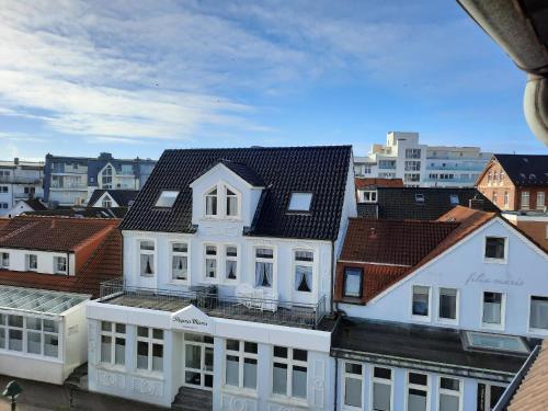 een groot wit gebouw met een zwart dak bij Moewennest-by-DeJu-Norderney in Norderney