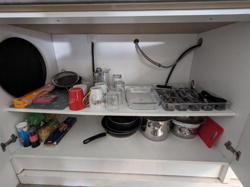 a kitchen shelf with various items on it at Appartement 100m2, indépendant dans notre maison in Garennes-sur-Eure