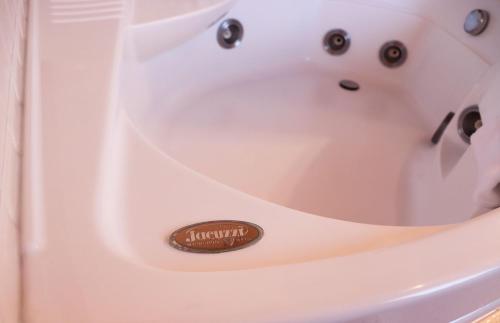a white bath tub with a sign that says luxury at Alice Relais Nelle Vigne in Vittorio Veneto