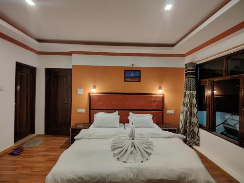 Dream Ladakh Guest House في ليه: غرفة نوم بسرير كبير مع شراشف بيضاء