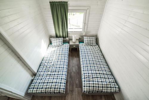 two beds in a room with a window at REST HOUSE WDZYDZE DOMKI NAD JEZIOREM in Wdzydze Kiszewskie