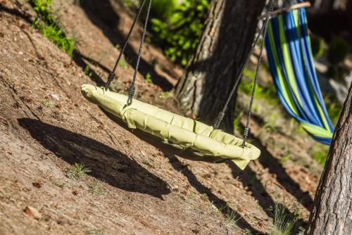 a hammock hanging from two trees in the dirt at REST HOUSE WDZYDZE DOMKI NAD JEZIOREM in Wdzydze Kiszewskie