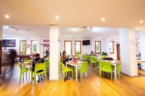 a group of people sitting at tables in a restaurant at Safestay Pisa Centrale in Pisa