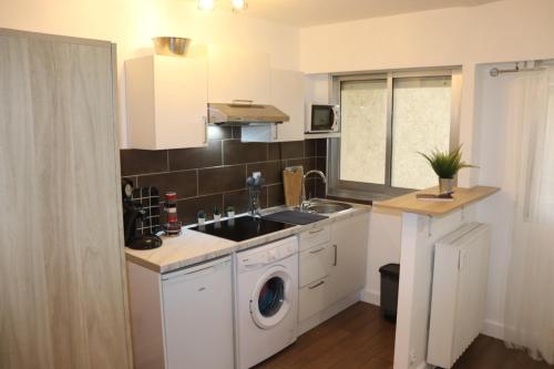une cuisine avec un évier et une machine à laver dans l'établissement Confort-Appartement cocooning ***, au Cannet