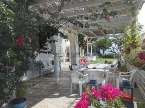 a patio with a table and chairs and flowers at House on the beach G&M in Nea Makri