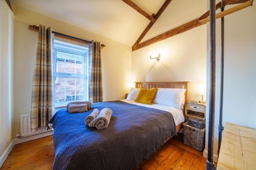 een slaapkamer met een bed met twee handdoeken erop bij 2 Eden Grove Cottages in Armathwaite