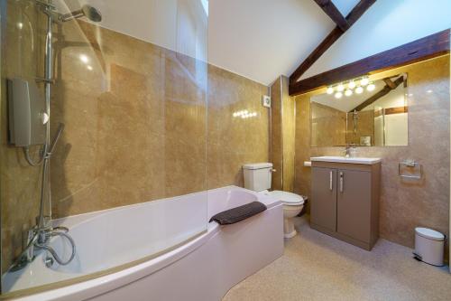 een badkamer met een bad, een toilet en een wastafel bij 2 Eden Grove Cottages in Armathwaite