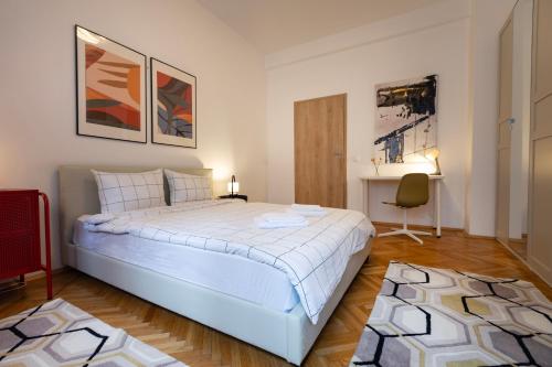a bedroom with a large white bed and a chair at Ultracentral Hong Kong 3 Bdrm apartment in Bucharest
