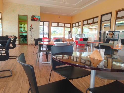 a dining room with tables and chairs in a restaurant at CENTRE NOURRI' SAINE in Allada