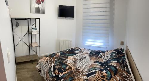 um quarto com uma cama e uma televisão na parede em Studio agréable em Le Havre