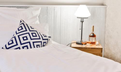 a bedroom with a bed with a bottle of wine and a lamp at Hotel Utspann Schafflund in Schafflund
