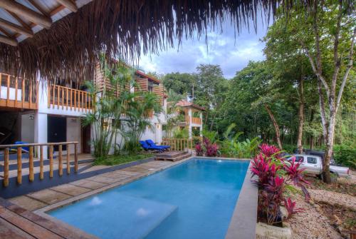 Playa Pelada的住宿－Treehouse Chilo at Hacienda Nosara，房屋前的游泳池