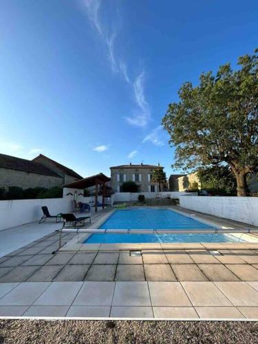 a swimming pool with a chair next to a house at Beautiful Charente Home with swimming pool in Marcillac-Lanville