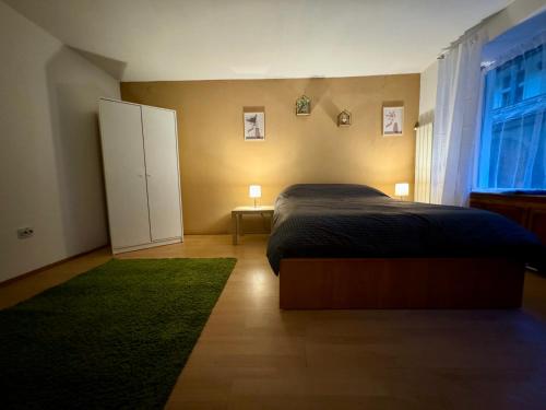 a bedroom with a bed and a green rug at Studio Luca in Sibiu
