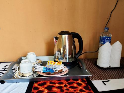 a tray with a tea kettle on a table at Milk House Cottage in Udawalawe