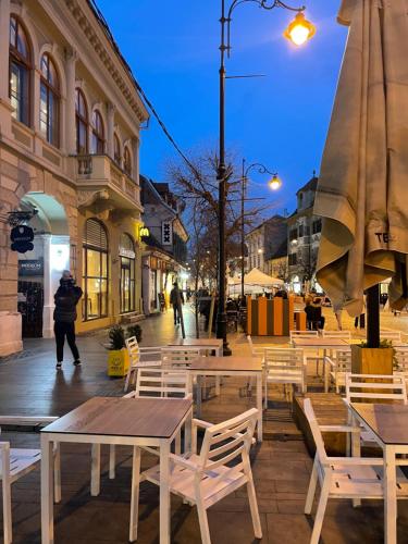 a group of tables and chairs on a city street at Studio Luca in Sibiu