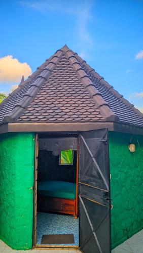 a green dog house with a brown roof at Châteaux Yolande in Mahajanga