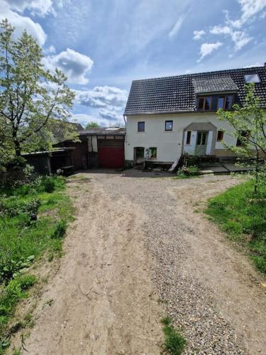 a dirt road in front of a house at Naturnahes Wohnen in einem alten Haus mit Garten in Windeck