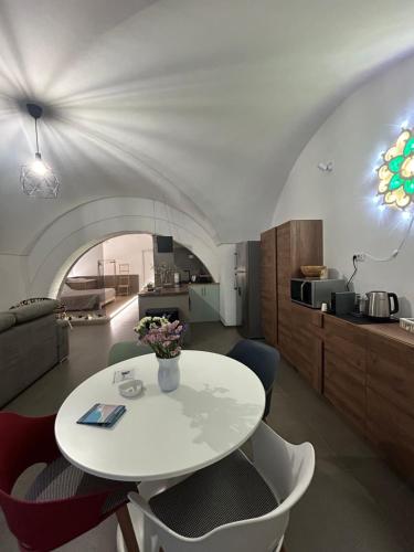 a dining room with a white table and chairs at Archome Luxury Apartment in Brindisi