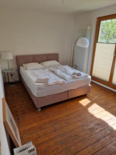 a bed in a bedroom with a wooden floor at Naturnahes Wohnen in einem alten Haus mit Garten in Windeck