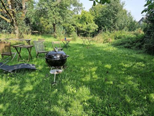 a grill sitting in the grass in a yard at Naturnahes Wohnen in einem alten Haus mit Garten in Windeck