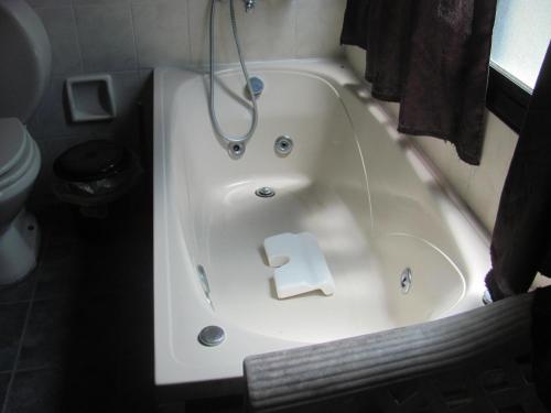 a bath tub with a roll of toilet paper in it at Posada Mar Azul con Jacuzzi in Punta Del Diablo