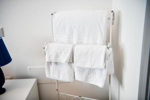 un toallero con toallas blancas en el baño en B&B Francesca, en Enna