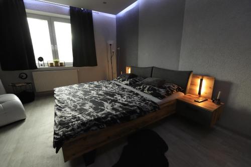 Schlafzimmer mit einem Bett mit einer schwarzen und weißen Bettdecke in der Unterkunft Wellness apartmán Apawell in Nezdenice