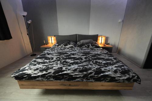 ein Bett in einem Zimmer mit zwei Nachttischen und einem Bett sidx sidx sidx in der Unterkunft Wellness apartmán Apawell in Nezdenice