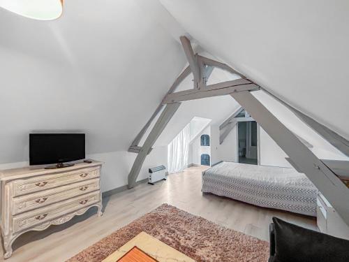 1 dormitorio con cama y vestidor con TV en La Chaumière de MÉDÉE, 
